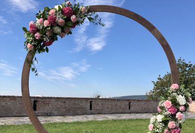 Kruhová slavobrána s růžemi, karafiáty a nevěstiným závojem. Svatební květiny Klára Uhlířová